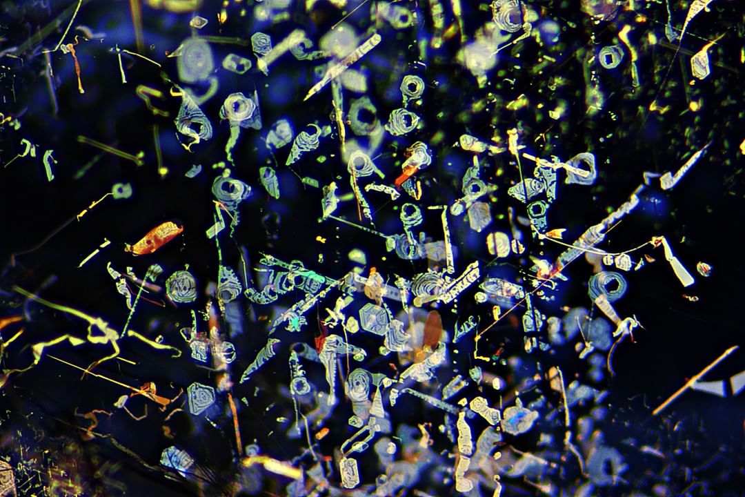 Microscope view of hematite and ilmenite inclusions inside gold sheen sapphire