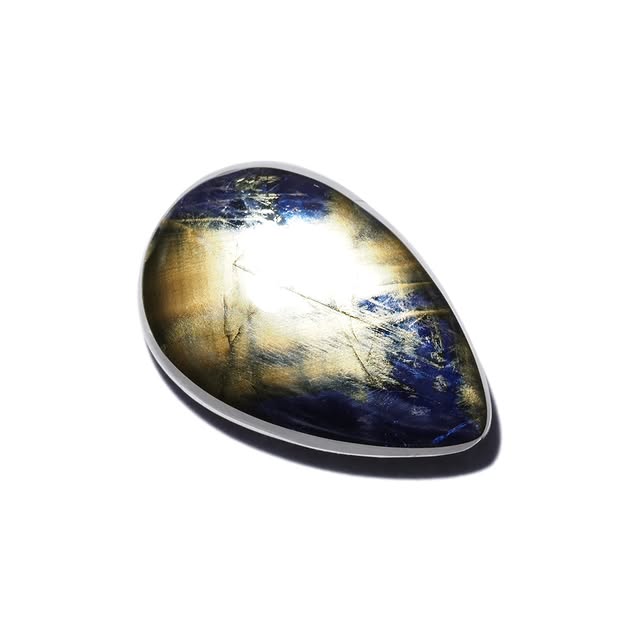 Polished gold sheen sapphire cabochon, teardrop cut, deep blue and gold banding, studio photograph on white
